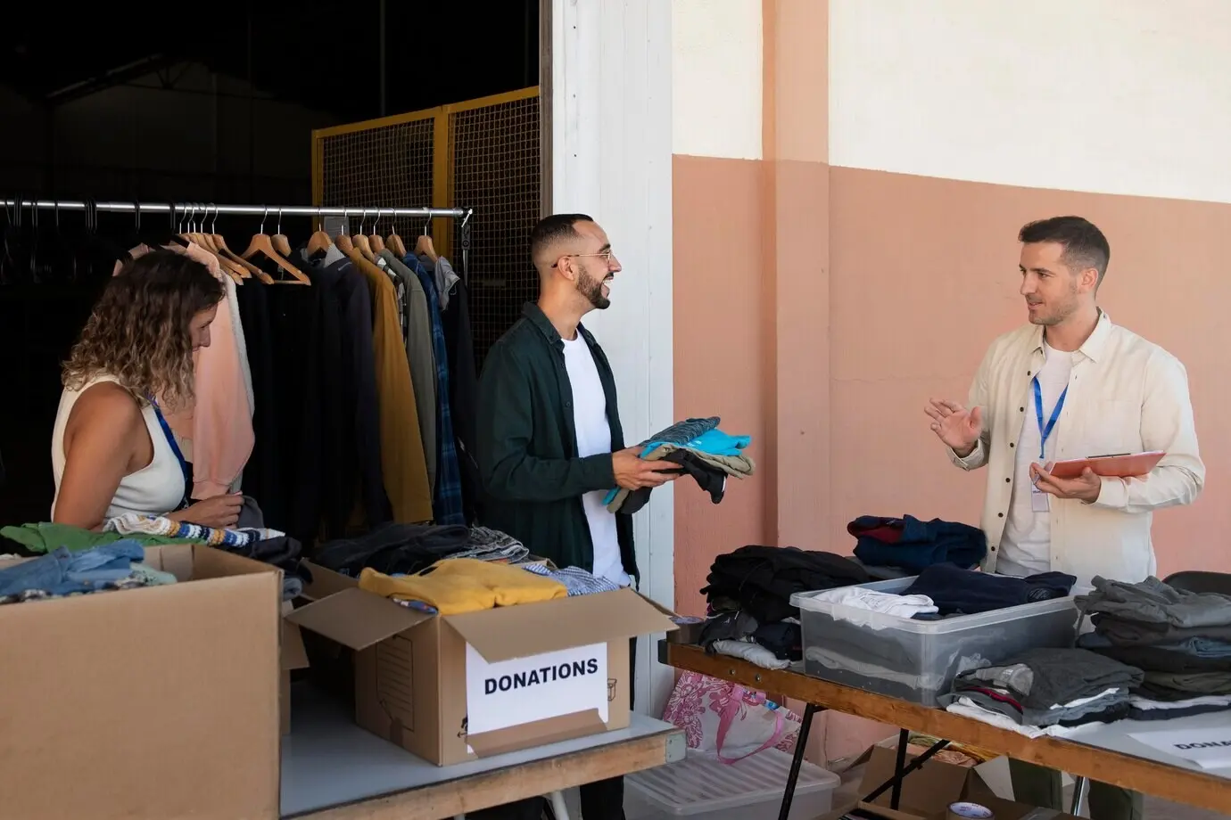Крупный план волонтёра, организующего вещи для пожертвования.